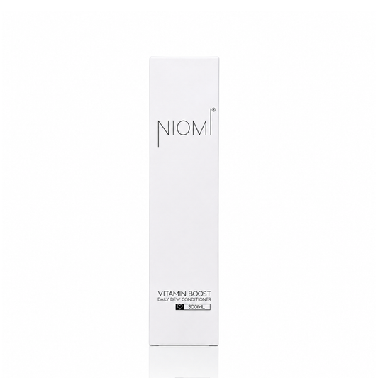 A tall, slim white rectangular box for NIOMI Vitamin Boost Daily Dew Conditioner featuring black text on a clean white background.