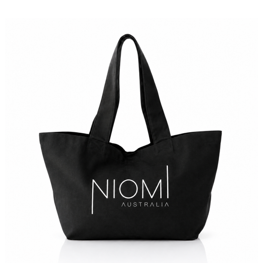 A black canvas tote bag with white printed text reading 'NIOMI AUSTRALIA' on the front, shown against a plain white background.