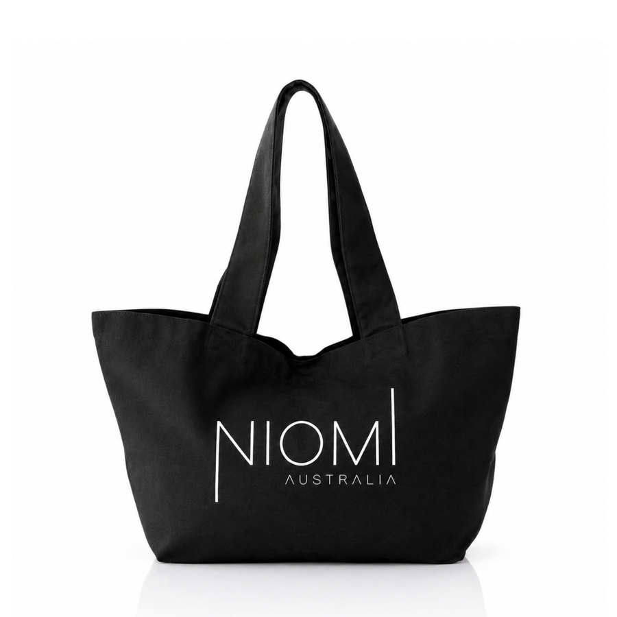 A black canvas tote bag with white printed text reading 'NIOMI AUSTRALIA' on the front, shown against a plain white background.